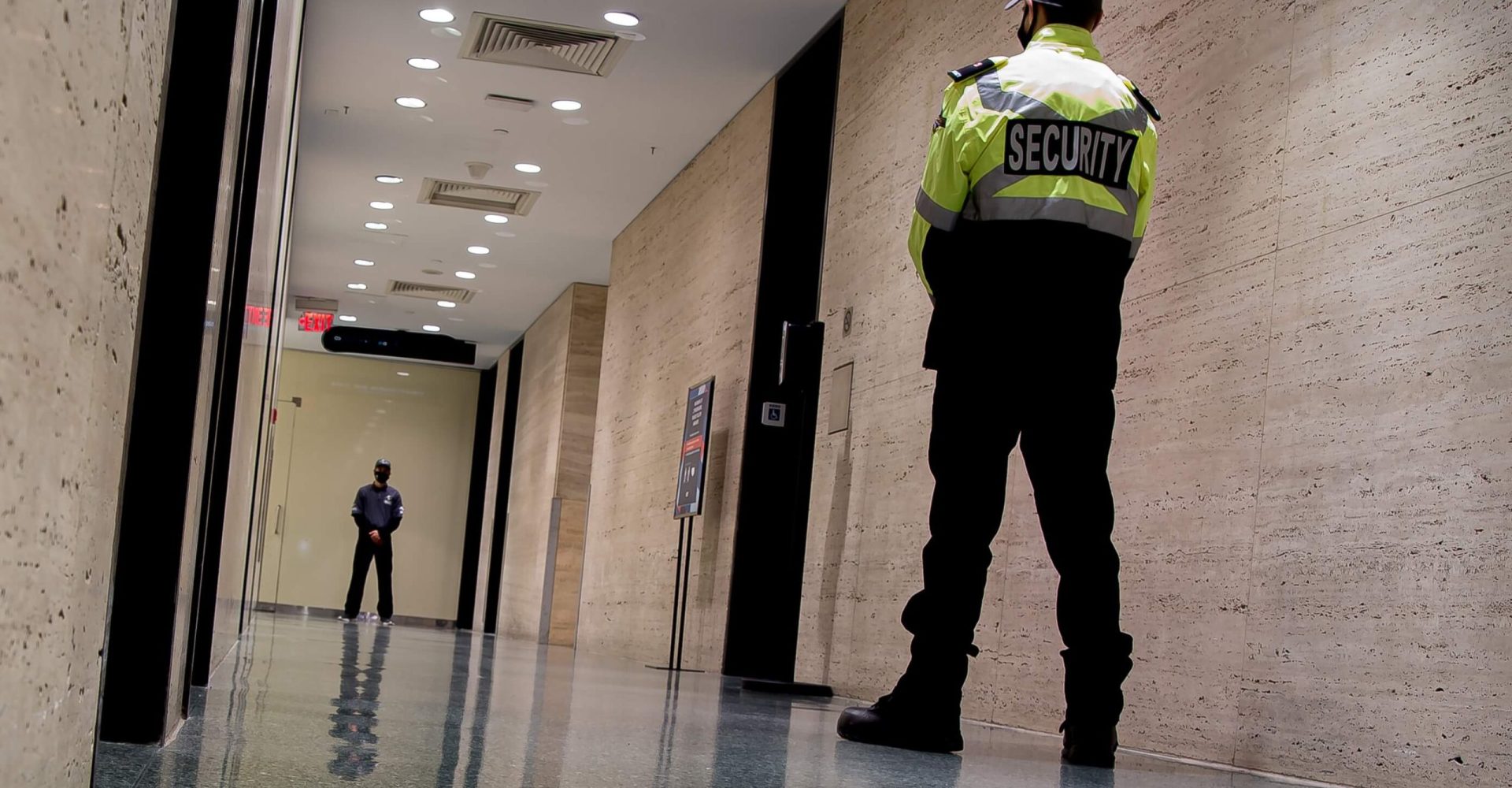 A man in uniform stands confidently in a well-lit hallway, ready for duty.