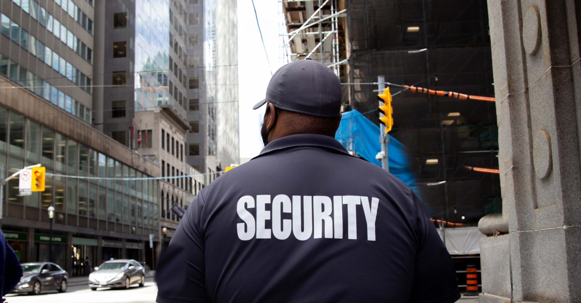 A man in a security uniform patrols a street, ensuring safety and vigilance in the area.