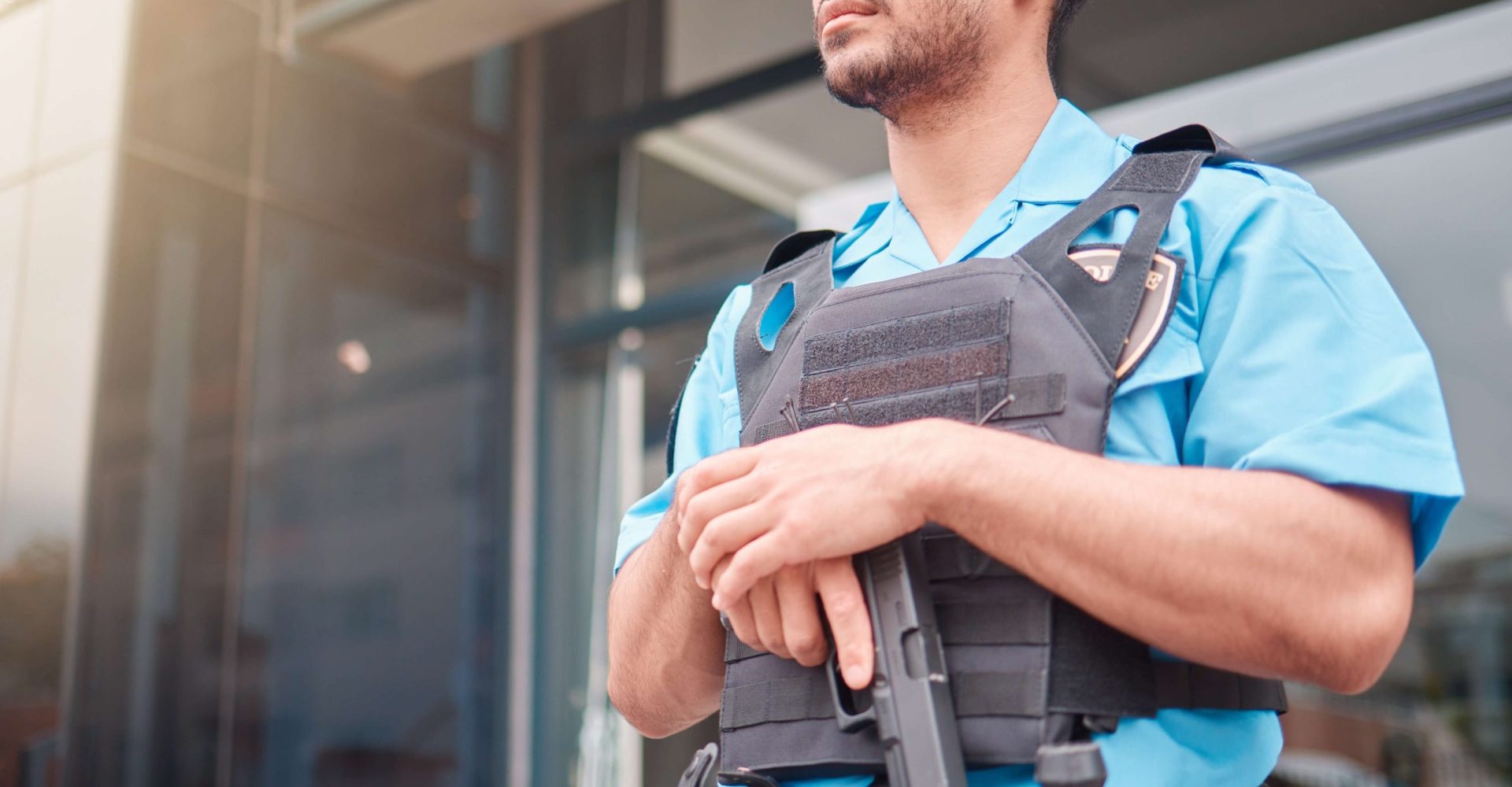 A police officer in uniform stands outside a building, ready to serve and protect the community.